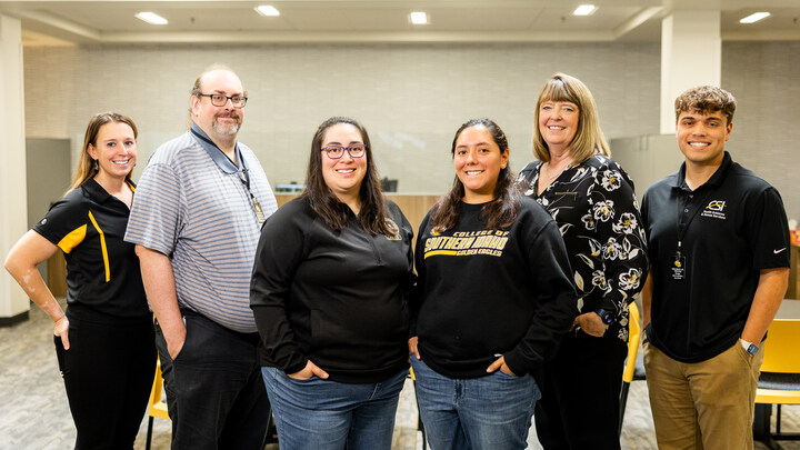 students at the doors of a college bulding, cheering