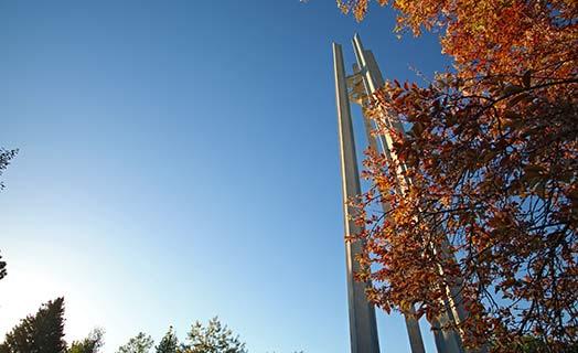 CSI Bell Tower in the fall with orange leaves on trees in the background