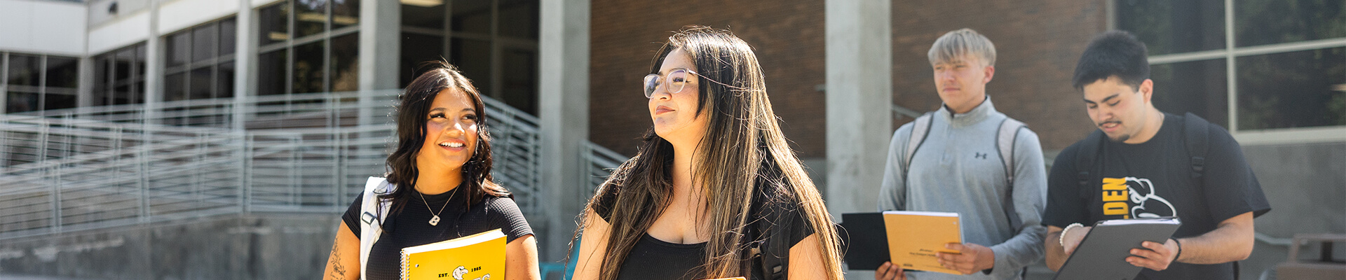 four students walking across the plaza