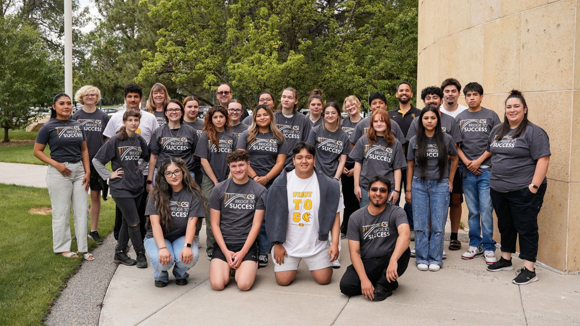 students at the doors of a college bulding, cheering